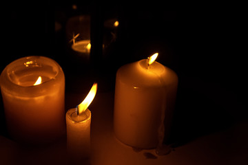 the flame of burning candles close-up macro on a dark black background