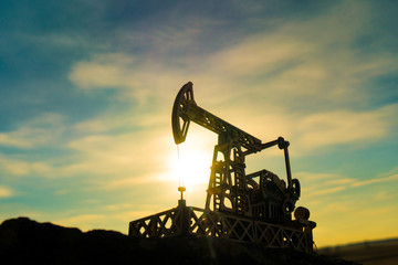 Oil pump on a sunset background. Oil production, fuel, natural resources.