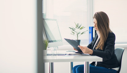 Image of young business woman working on project at office