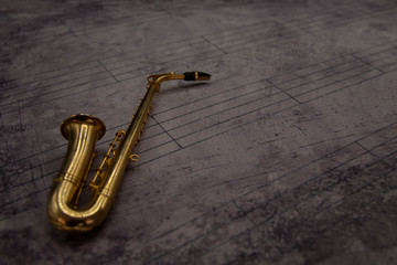 Fototapeta na wymiar Fondo partitura con instrumento en miniatura