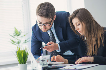 Obraz premium Young businessman discussing something with his colleague