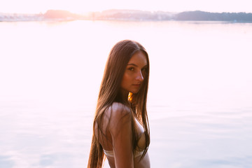 Naklejka premium Beauty model portrait in the sunrays. Paradise beach. Woman beauty, body care. Young skin. Summer vacation.