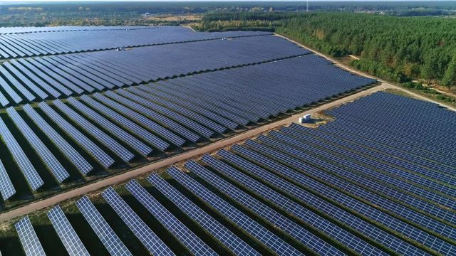 Aerial drone footage. Radial flight over solar panel farm.