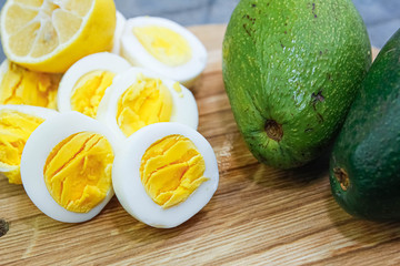 boiled eggs with avocado on a wooden board.