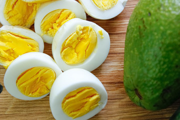 boiled eggs with avocado on a wooden board.