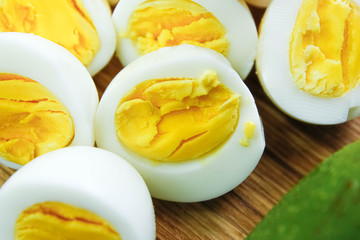 boiled eggs with avocado on a wooden board.