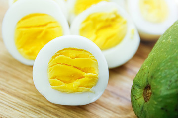 boiled eggs with avocado on a wooden board.