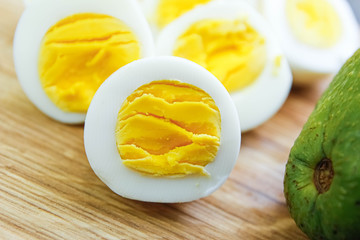 boiled eggs with avocado on a wooden board.