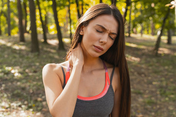 Sportswoman hurting her neck during the workout