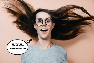 Portrait of woman in glasses with flying hair in panic looks with surprised expression on pastel orange background. Concept of black friday, cyber monday, purchases. Online shops and payments bill