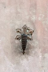 Decorative old rusty spiral flag handle on a wall
