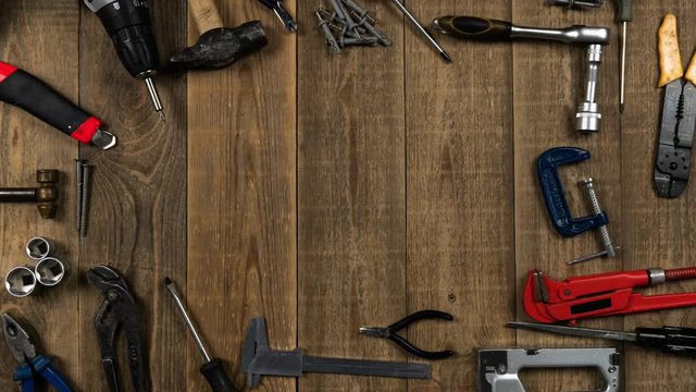 Logo Intro animation of repair tools on a wooden table top view. Theme stop motion hand tools for logo intro. Concept of brand promotion for the provision of repair services, locksmith or woodworker.
