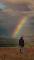 Man enjoying the rainbow and the view. Benbulben, Dartry mountains. Count Sligo, Ireland