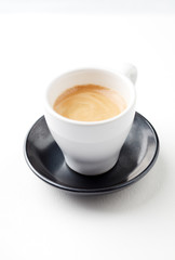 Cup of coffee on white paper background. Close up. Copy space.