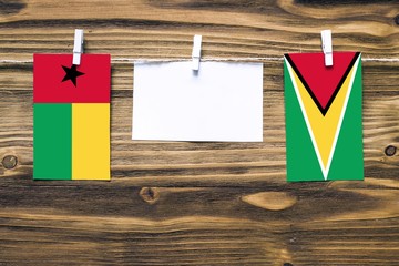 Hanging flags of Guinea Bissau and Guyana attached to rope with clothes pins with copy space on...