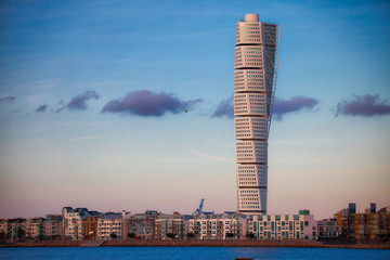 Turning torso of malmö skyline with blue sky and few clouds and sea
