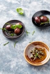 Kalamata olives and capers on bright wooden background. Close up. 