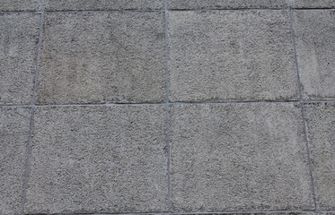 Fototapeta premium Gray concrete wall of a prefabricated house. Squares. Concrete and stone.