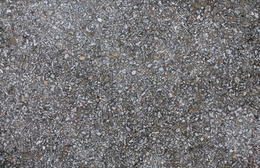 Old gray asphalt with large white stones. Texture for creative design.