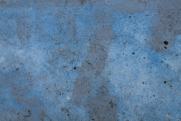 Old dirty concrete surface with uneven blue paint and black spots. Texture for creative design.