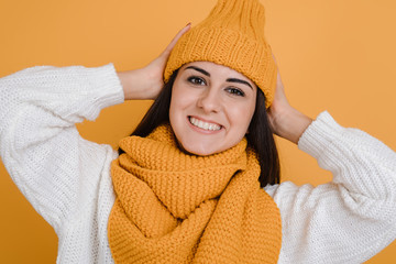 Close up portrait of a beautiful brunette in orange hat, smiles sincerely