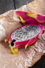 cut fresh pitahaya on a craft paper. vertical