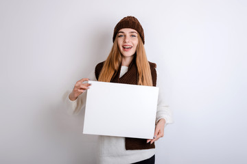 Naklejka premium Young woman holding a blank sign in front oh her face