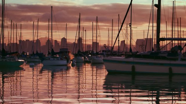 Sailboat docks in a marina at dusk