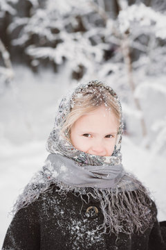 Portrait of snow-covered little girl in winter forest