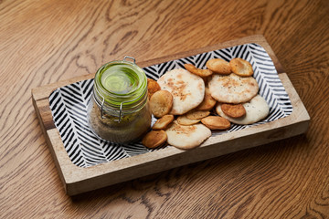 Homemade chicken liver pate in the jar on a wooden table, close-up.