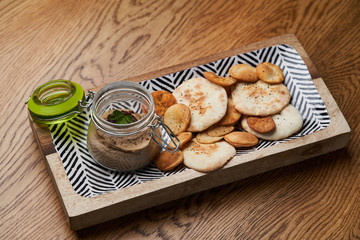 Homemade chicken liver pate in the jar on a wooden table, close-up.