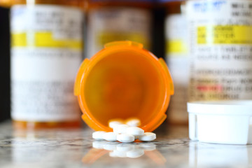 Precription bottles of pain pills on a granite countertop. 