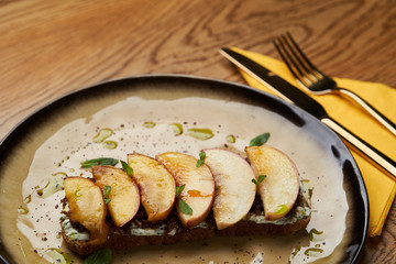 Traditional italian bruschetta with duck fillet, cream cheese and peach, close-up