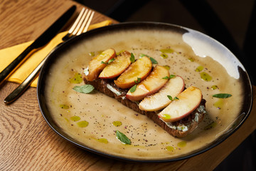 Traditional italian bruschetta with duck fillet, cream cheese and peach, close-up