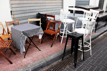 Chairs of different styles and colors next to the cafe.