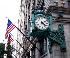 Fototapeta na wymiar Chicago, old blue clock on the street corner and flags