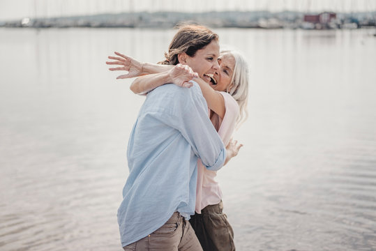 Mother and daughter spending a day at the sea, laughing and embracing