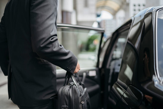 Mid-section of businessman getting into a taxi