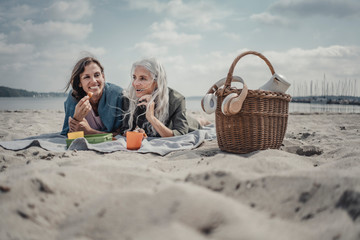 Mother and daughter having a picnic on the beach