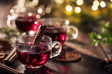 A red drink with a cinnamon stick in a small glass cup