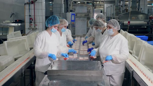 Plant premises with female employees packing fish snacks