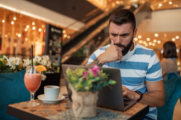 Young man using laptop in cafe