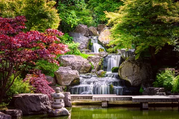 Foto op Plexiglas Watervallen Waterval lange blootstelling met esdoorns en brug in Kyoto Japanse groene tuin in Holland Park groene zomer zen meer vijverwater in Londen, Verenigd Koninkrijk