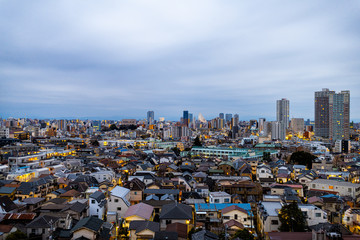 Shinjuku cityscape in Tokyo, Japan at dark stormy night with apartment buildings skyline and towers illuminated nightlife