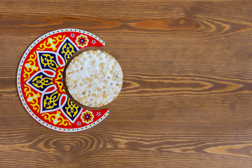 Arabian Islamic Background - Arabian Crescent with Islamic Texture with a piece of Halawet Al Mawlid Al Nabawi - Traditional candy - Egyptian Culture Dessert 