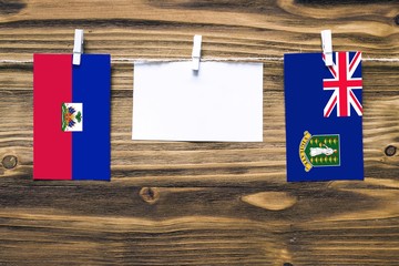 Hanging flags of Haiti and British Virgin Islands attached to rope with clothes pins with copy...