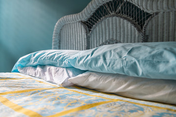 Closeup of clean bed vintage beach theme decorative blue pillows in bedroom home, house or apartment and headboard