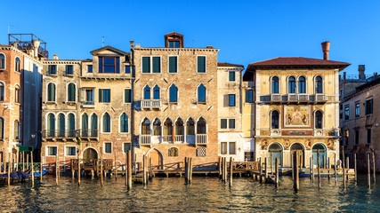 Vintage houses, Venice, Italy. Front view of facades of residential buildings on Grand Canal. Panorama of embankment in the Venice city center in summer. Scenery of old street in Venice on sunny day.