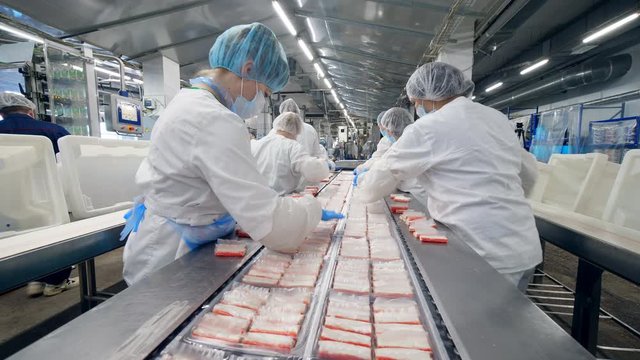 Packaging of crabs sticks carried out by female plant staff