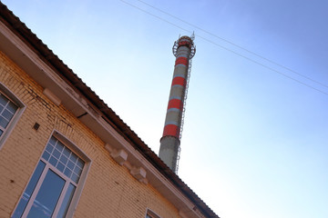 High red and white water tower on a sunny day against the blue cloudless sky